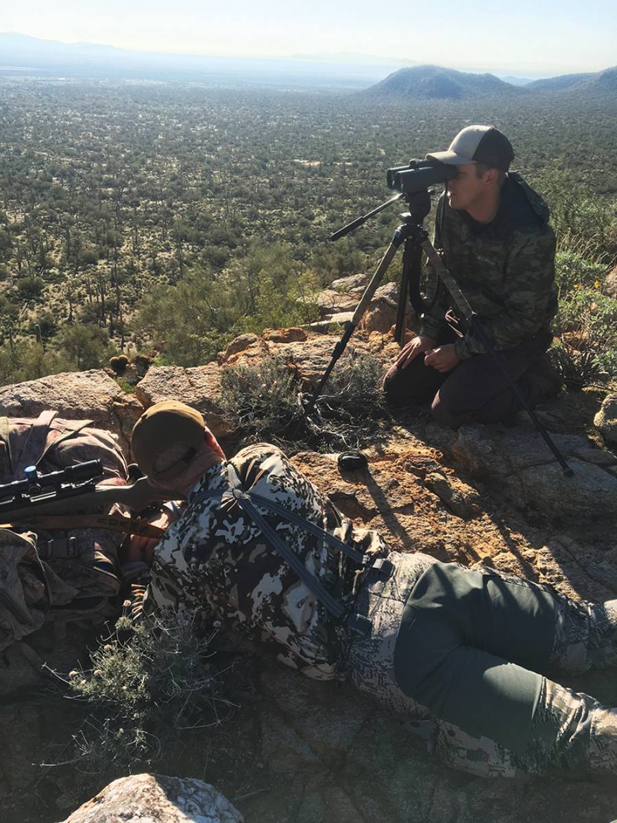 Tol is preparing to shoot from prone while guide Shane Yount gives him landmarks to find the buck in the scope.